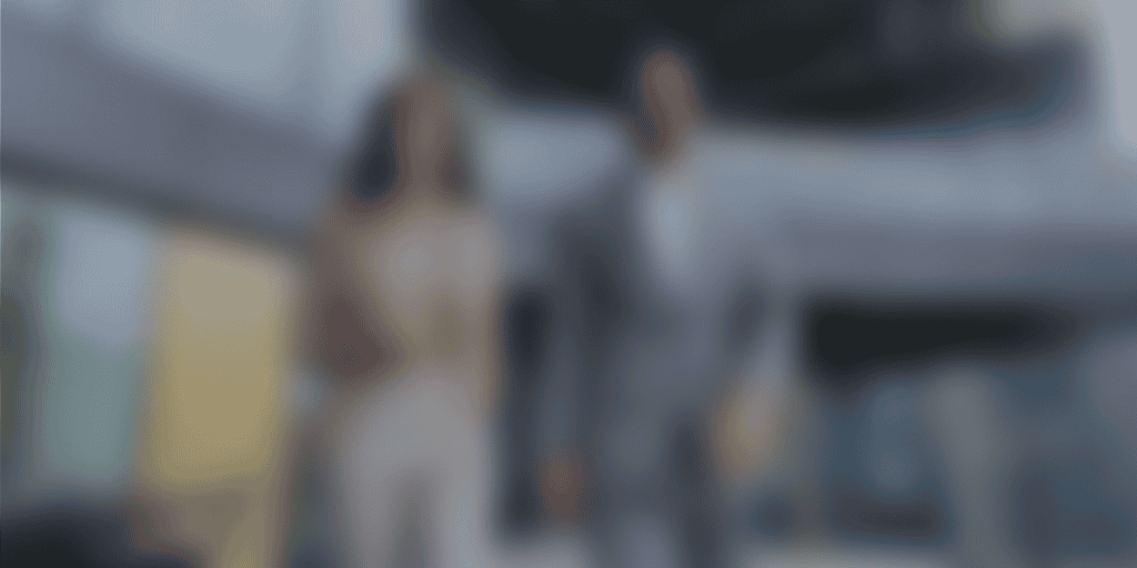 Pareja caminando en un entorno arquitectónico contemporáneo, mostrada de forma intencionadamente desenfocada, con la marca The Core como elemento visual, simbolizando foco, acompañamiento y liderazgo compartido.