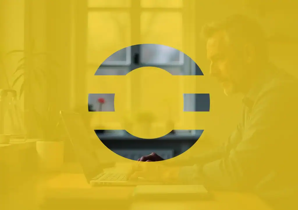 Persona trabajando concentrada frente a un ordenador en un entorno profesional, cubierta por una capa gráfica amarilla con el logotipo de The Core en primer plano, simbolizando enfoque, método y desarrollo interior aplicado al liderazgo.