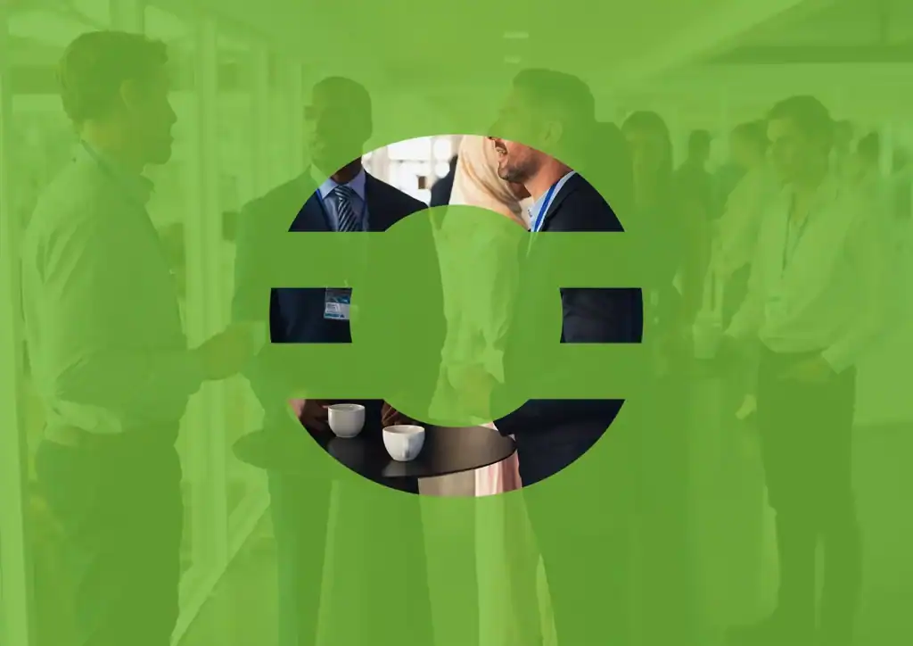 Profesionales interactuando en un evento corporativo, conversando de forma cercana alrededor de una mesa, con el logotipo de The Core superpuesto, representando conexión, networking estratégico y liderazgo relacional en entornos profesionales.