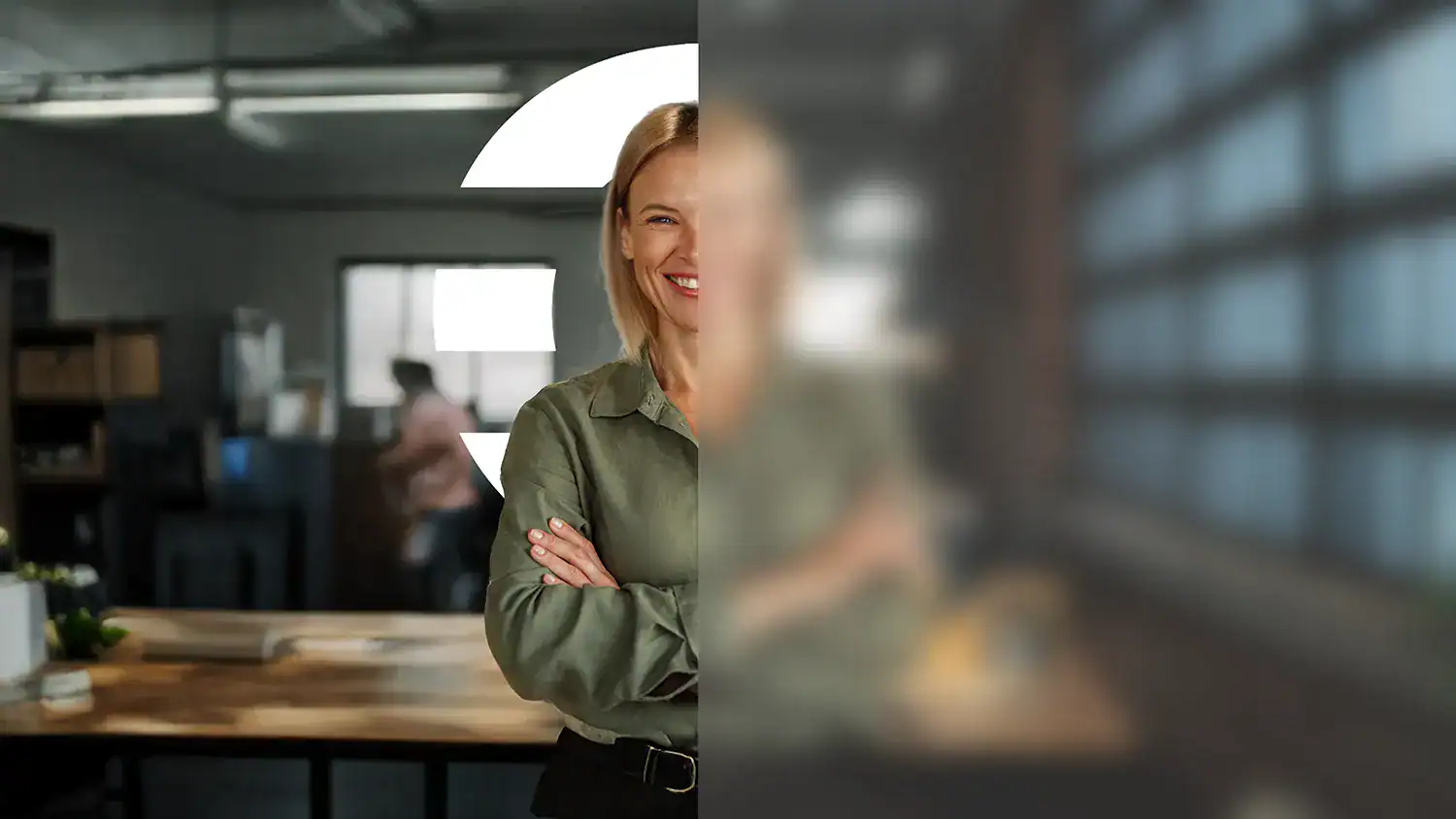 Mujer en un espacio de trabajo con los brazos cruzados, con efecto de desenfoque parcial y el símbolo gráfico de The Core.