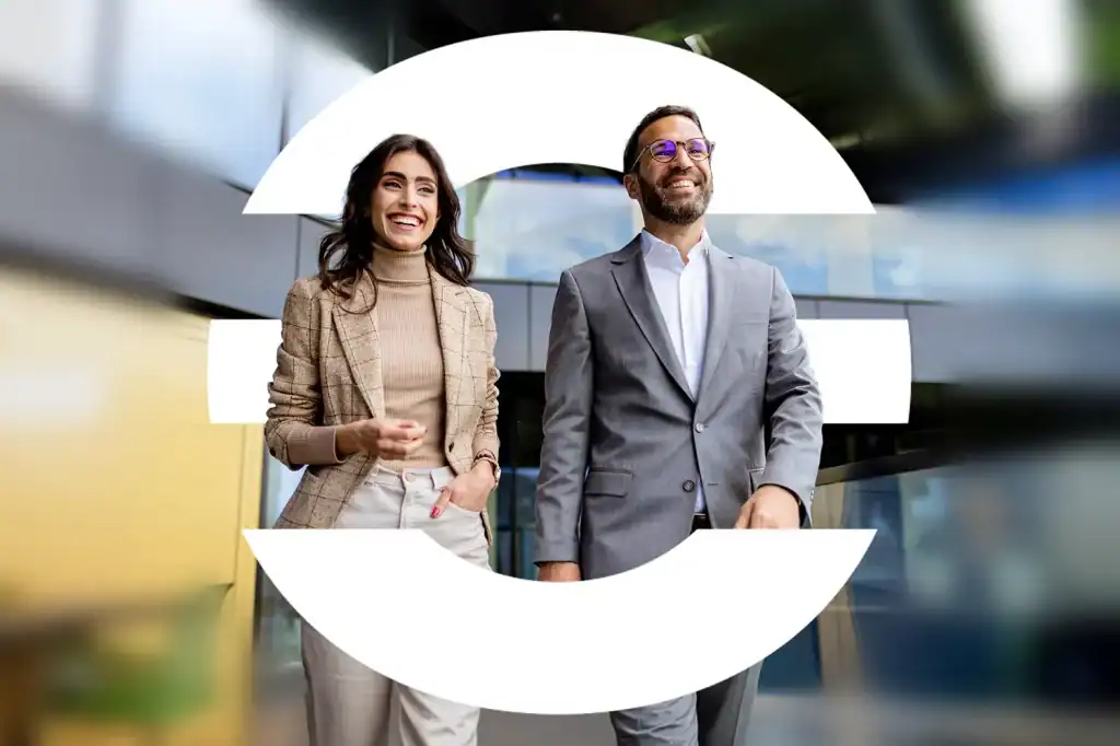 Dos profesionales caminando juntos en un entorno corporativo moderno, con el logotipo de The Core superpuesto, simbolizando liderazgo compartido, colaboración y crecimiento profesional alineado con una visión común.